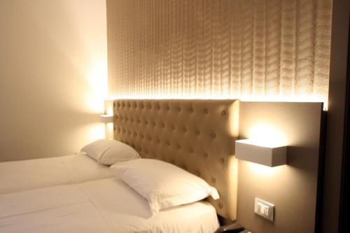 a bedroom with a bed with a headboard and a lamp at Hotel Principe in Modena