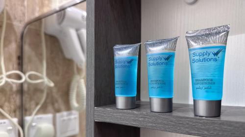a shelf with three bottles of sunscreen on it at قصر لوماج - احد رفيدة in Ahad Rafidah