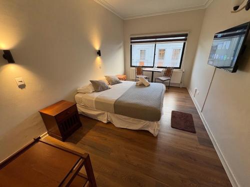 ein Schlafzimmer mit Bett, Tisch und Fernseher in der Unterkunft Budget Hotel Central in Osorno