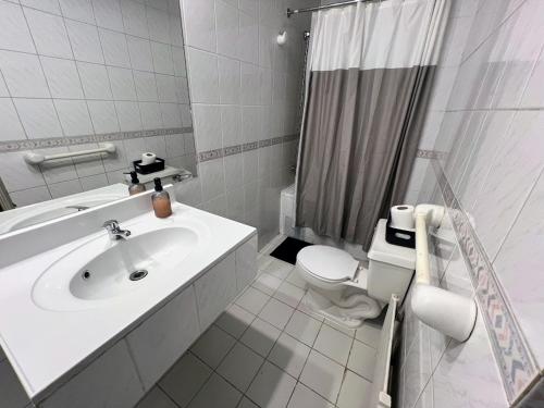 ein weißes Badezimmer mit Waschbecken und Toilette in der Unterkunft Budget Hotel Central in Osorno