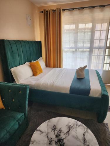 a bedroom with a bed and a couch and a window at PiemStays in Ruaka