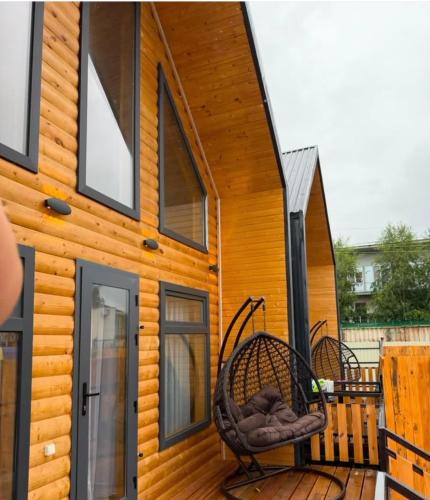 a house with a porch with two chairs on a deck at Esal house in Chon-Sary-Oy