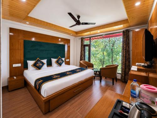 a bedroom with a bed and a desk and a window at Kavin Highland - The Mall Dalhousie in Dalhousie