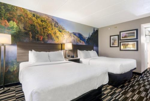 two beds in a hotel room with a painting on the wall at Clarion Pointe Richmond North near University in Richmond