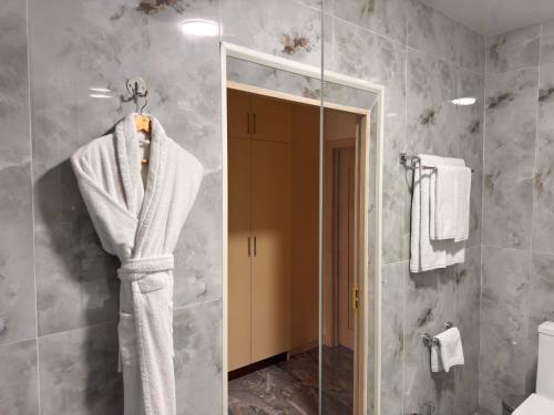 a bathroom with a white towel hanging on a mirror at The Tower Hotel Tashkent by HotelPro Group in Tashkent