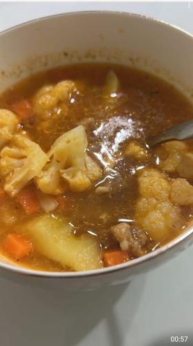 a bowl of soup with chicken and vegetables at Azamat Yurt Camp in Song-Kul