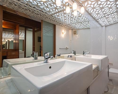 a bathroom with two sinks and a mirror at Pattaya Bungalow III, Totally Private Pool in Pattaya South