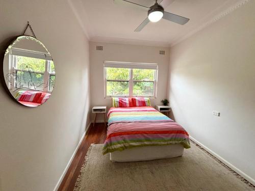 a bedroom with a bed and a mirror at Conns Cottage - Bring your own linen in South West Rocks
