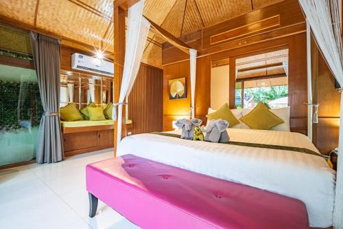 two stuffed elephants sitting on a bed in a room at Pattaya Bungalow III, Totally Private Pool in Pattaya South