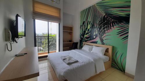 a bedroom with a bed with a painting on the wall at Dave Apartment in Pondoktjina Tiga
