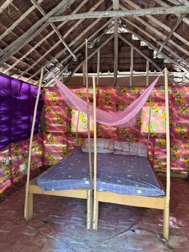a bed in a room with a mosquito net at Twin Beach Bungalows in Loh
