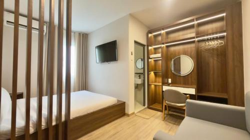 a hotel room with a bed and a desk and a mirror at Ann Arbor Hotel in Ho Chi Minh City