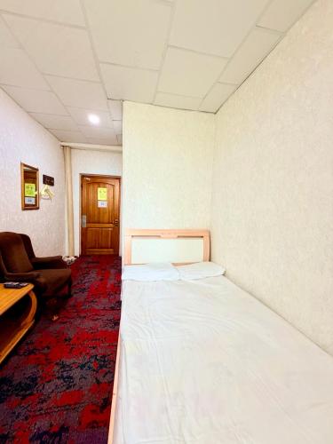 a room with a bed and a chair in it at City Hostel & Tours in Ulaanbaatar