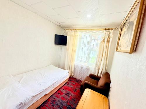 a small bedroom with a bed and a window at City Hostel & Tours in Ulaanbaatar