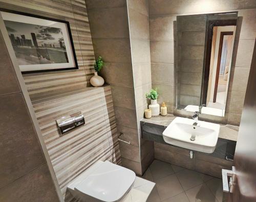 a bathroom with a toilet and a sink at Saadiyat Serenity 1BR apartment with Beach access in Abu Dhabi