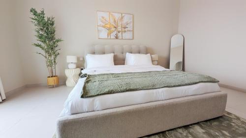 a bedroom with a large bed with white walls at Saadiyat Serenity 1BR apartment with Beach access in Abu Dhabi