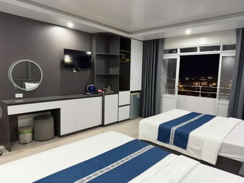 a hotel room with two beds and a mirror at SunWay hotel in Cat Ba