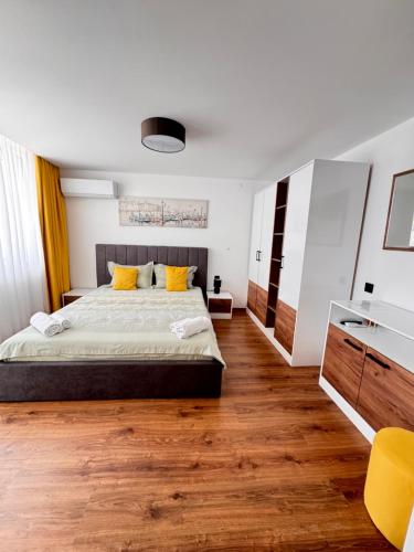 a bedroom with a large bed and wooden floors at Вила TIMeS in Kiten
