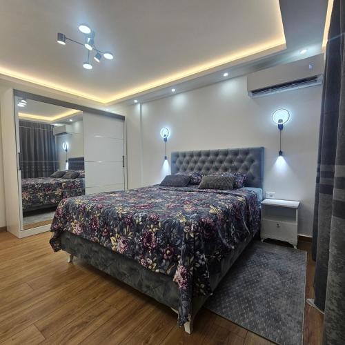 a bedroom with a large bed and a mirror at Stan na dan Bijeljina centar 2 in Bijeljina