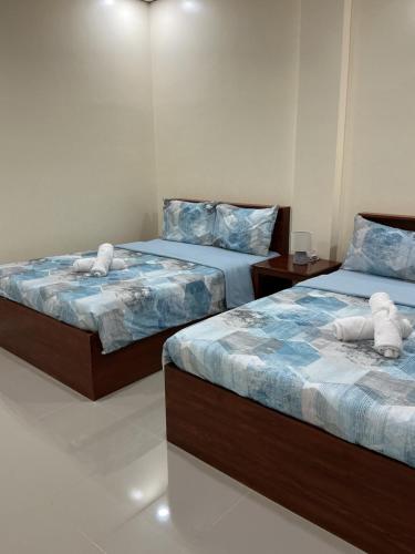 two beds in a bedroom with white towels on them at SabinaGateway Suites in Panglao Island
