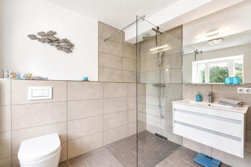 a bathroom with a shower and a toilet and a sink at Ferienwohnung Aquamarin im Haus Arkona Prora in Binz