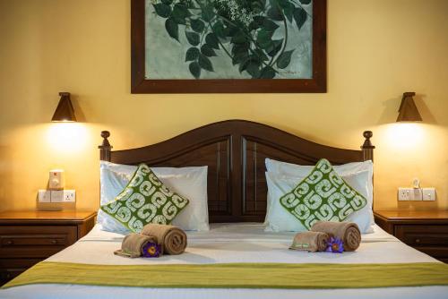 a bedroom with a bed with two pillows on it at Jasmin Villa Ayurveda Resort in Negombo