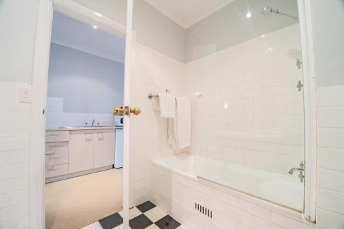a white bathroom with a tub and a sink at St Francis Winery in Old Reynella