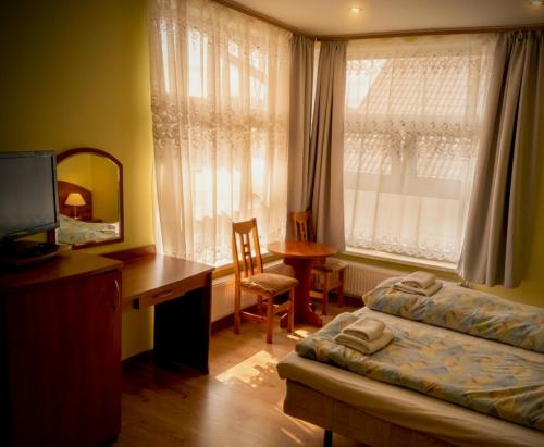 a bedroom with a bed and a desk and a desk at Villa Aqua in Międzyzdroje