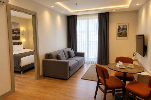 a living room with a couch and a table and a bed at Rai Premium İstanbul in Istanbul