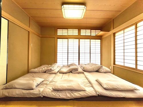 a large bed in a room with two windows at 蒼のSkyviewBase in Hiroshima