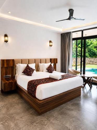 a bedroom with a large bed and a table at Kaya Nature Resort in Ajabgarh