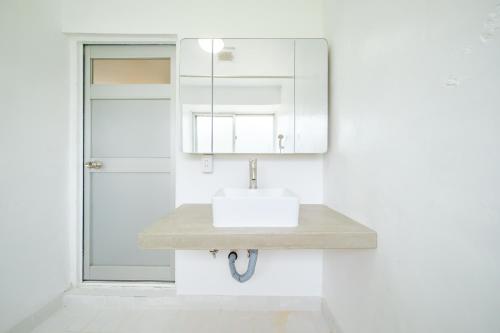 a bathroom with a sink and a mirror at ふんわり in Miyakojima