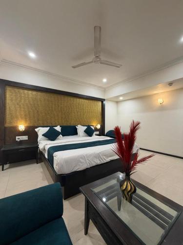 a bedroom with a bed and a table and a couch at hotel royal highness in Ahmedabad