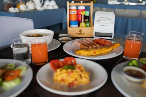 a table topped with plates of food and drinks at Chareena Hill Beach Resort in Ko Lipe