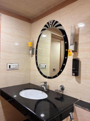 a bathroom with a sink and a mirror at hotel royal highness in Ahmedabad