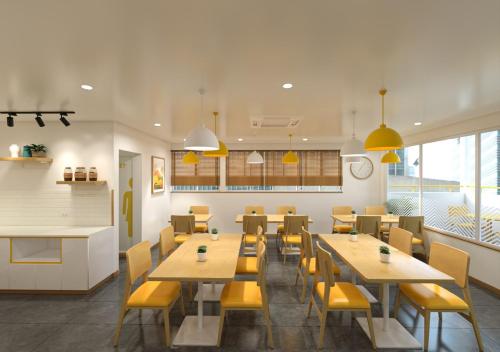 a restaurant with wooden tables and yellow chairs at Bloom Hotel CMH Road Indiranagar in Bangalore