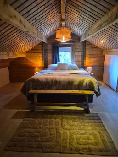 a bedroom with a large bed in a wooden room at Het Leendernest in Leende