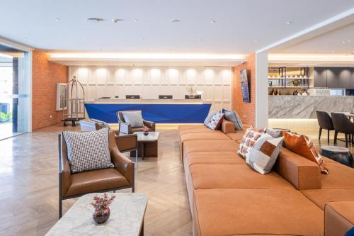 a living room with a large couch and chairs at Blue Hippo & Red Crocodile Hotel in Bangna