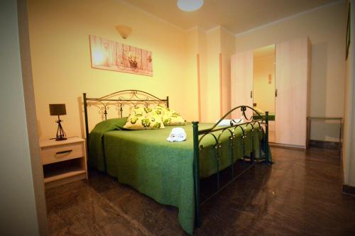 a bedroom with a green bed and a night stand at Ciao Bello B&B in Martina Franca