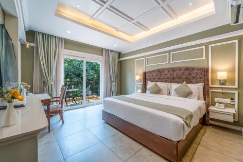a bedroom with a large bed and a table and a desk at De Amour - A Dreamy Getaway in Anjuna in Anjuna