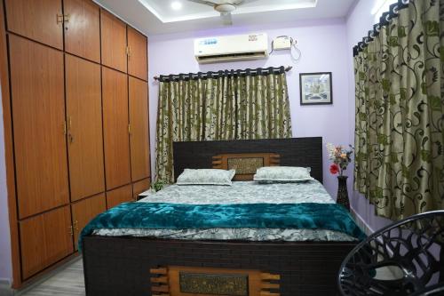 a bedroom with a bed in a room with wooden cabinets at Manavididillu 4BHK DUPLEX VILLA in Rājahmundry