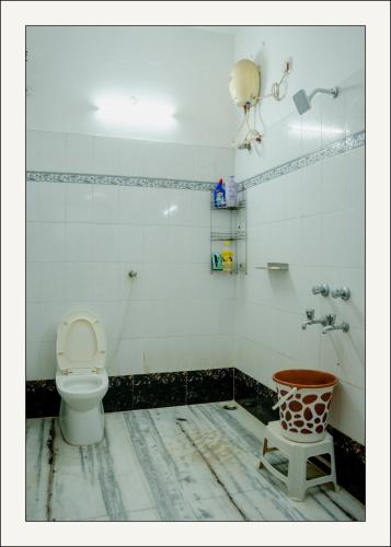 a dirty bathroom with a toilet and a stool at Manavididillu 4BHK DUPLEX VILLA in Rājahmundry