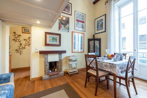 a dining room with a table and a fireplace at Regina - Duplex in Heart of Menton - Happy Rentals in Menton