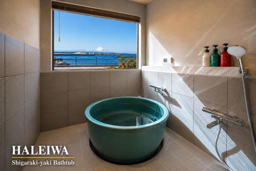 a bath tub in a bathroom with a window at 千葉地域ランキング1位獲得の贅沢な貸別荘全4棟 in Hota