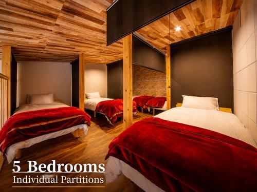 two beds in a room with wooden ceilings at 千葉地域ランキング1位獲得の贅沢な貸別荘全4棟 in Hota