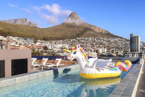 a pool with an inflatable unicorn on the roof of a building at THREE43 ON B - Fluent Serviced Apartments in Cape Town