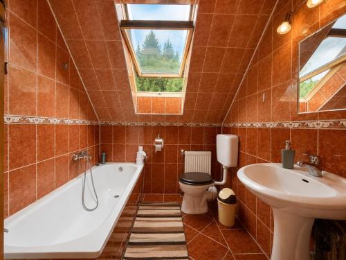 a bathroom with a tub and a toilet and a sink at Égéspatak Vendégház in Ghiduţ