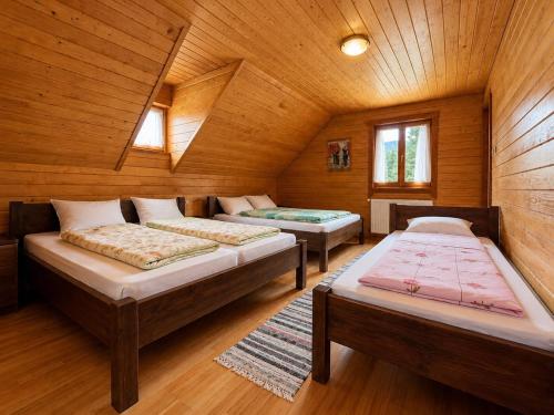 a room with three beds in a wooden cabin at Égéspatak Vendégház in Ghiduţ