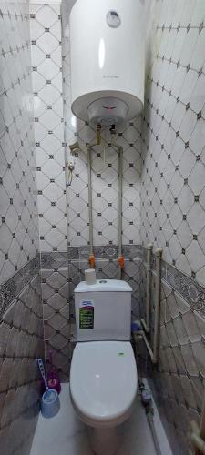 a bathroom with a white toilet and a tank at Толе би 141А in Qyzylorda