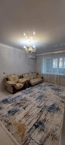 a living room with a bed and a large rug at Толе би 141А in Qyzylorda